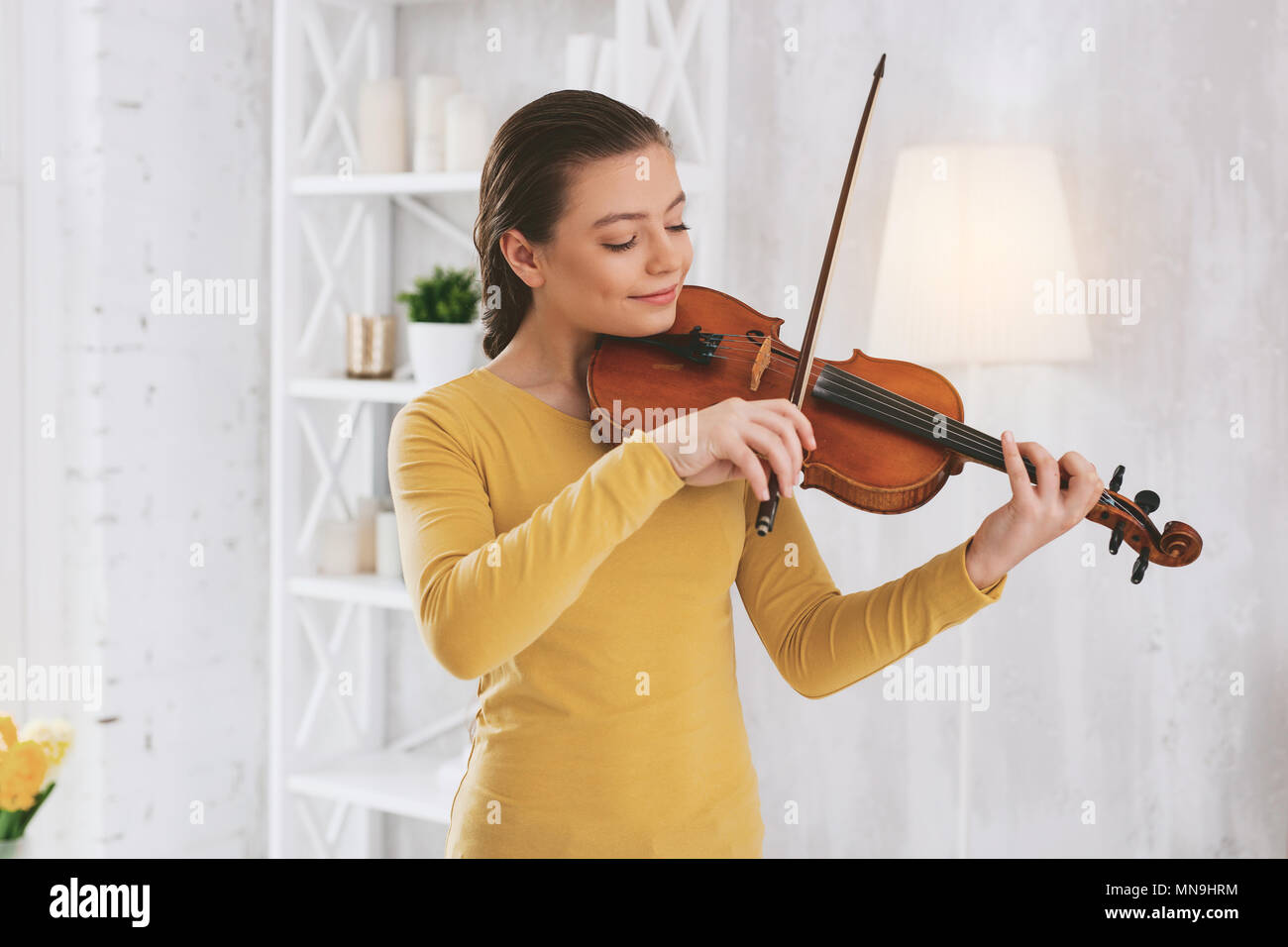 Delighted brunette playing the violin Stock Photo