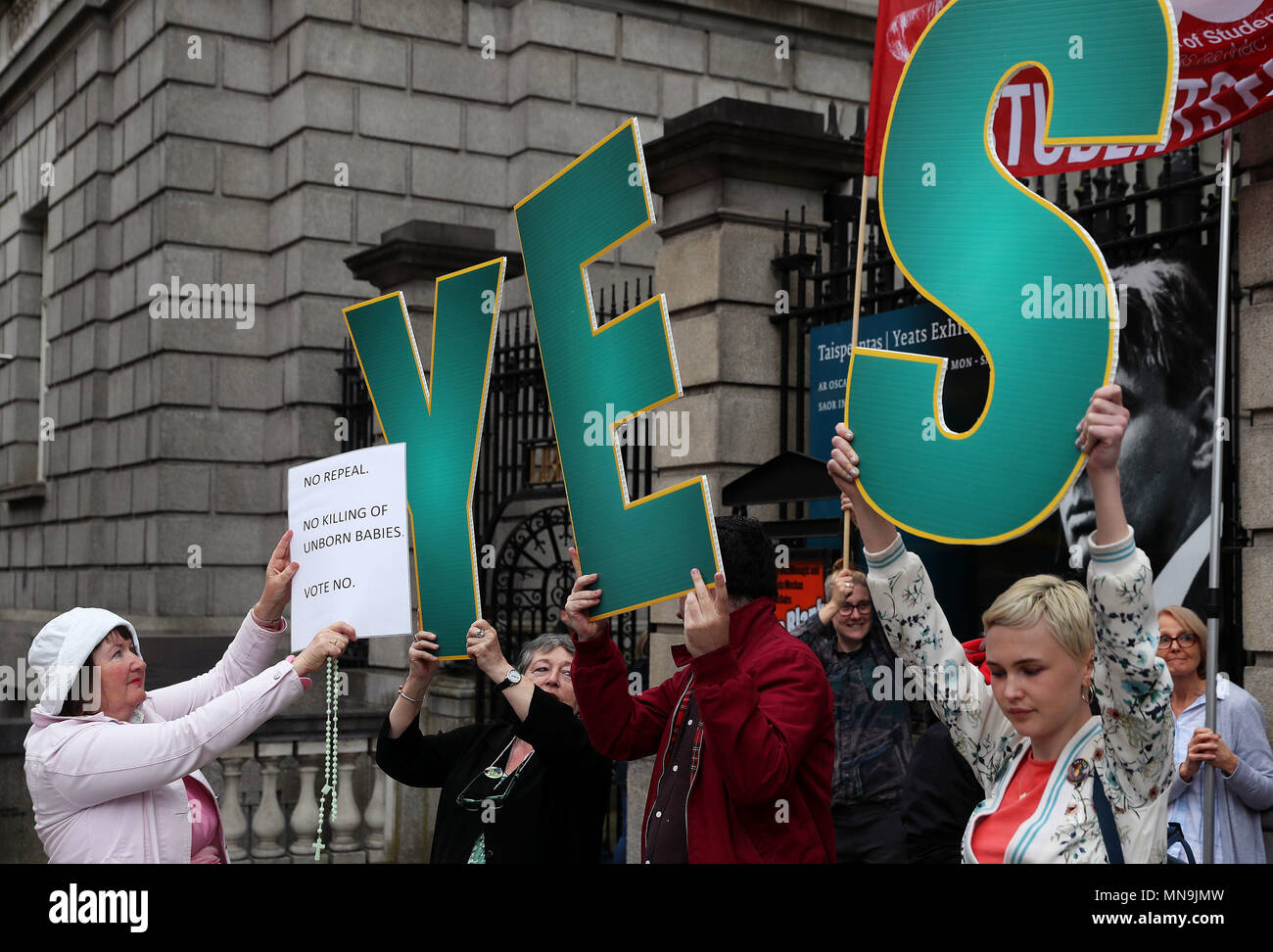 An anti-abortion campaigner holds a sign up in front of pro-choice campaigners outside Leinster House, Dublin, ahead of the referendum on the 8th Amendment of the Irish Constitution on May 25th. Stock Photo