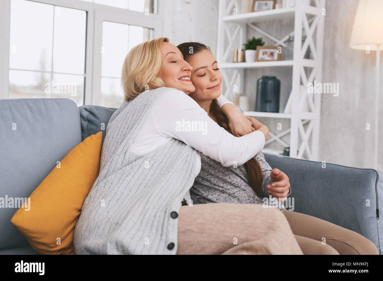 Pleased blonde embracing her daughter Stock Photo