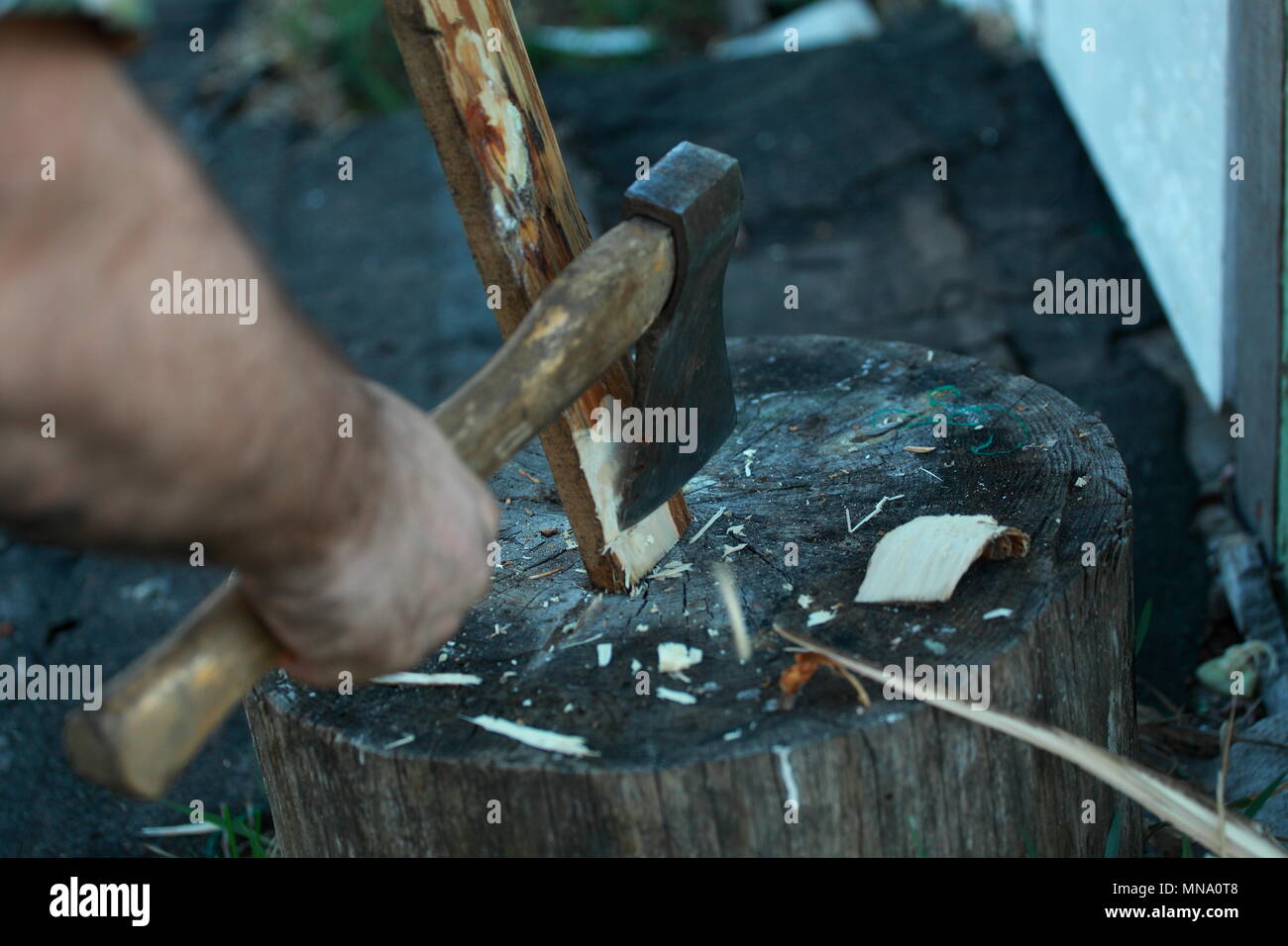 The blow of the axe on the Board. Cut the tree. Man chopping wood. Stock Photo