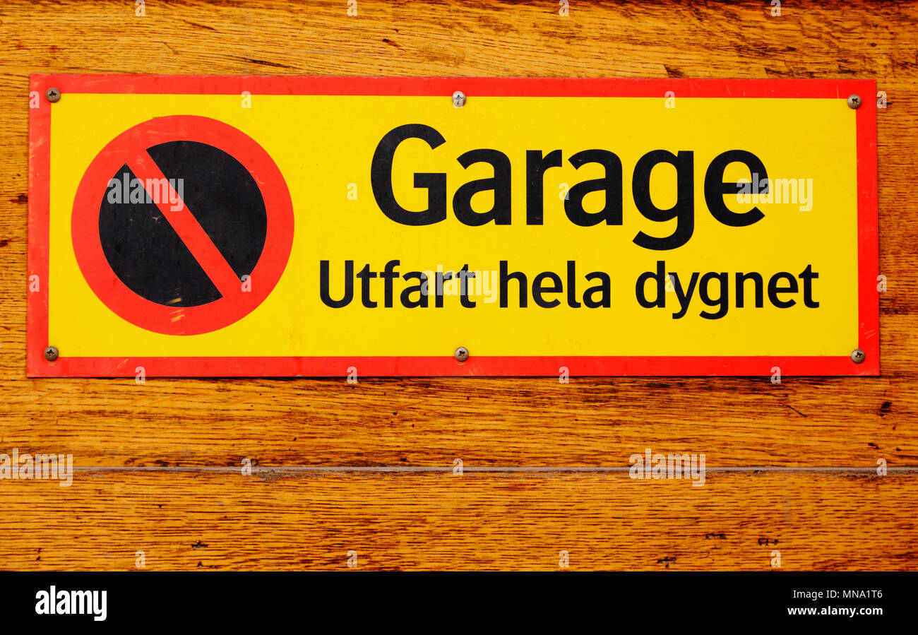 Sign stating that it is no parking, driveway with text written in