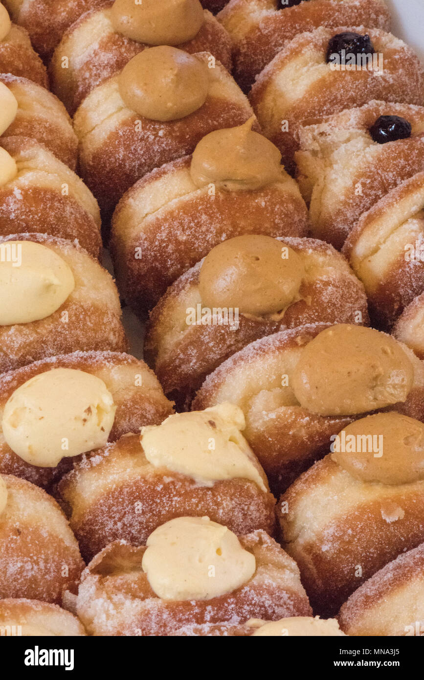 custard and jam sugar coated sticky sweet cakes and doughnuts or donuts. Stock Photo
