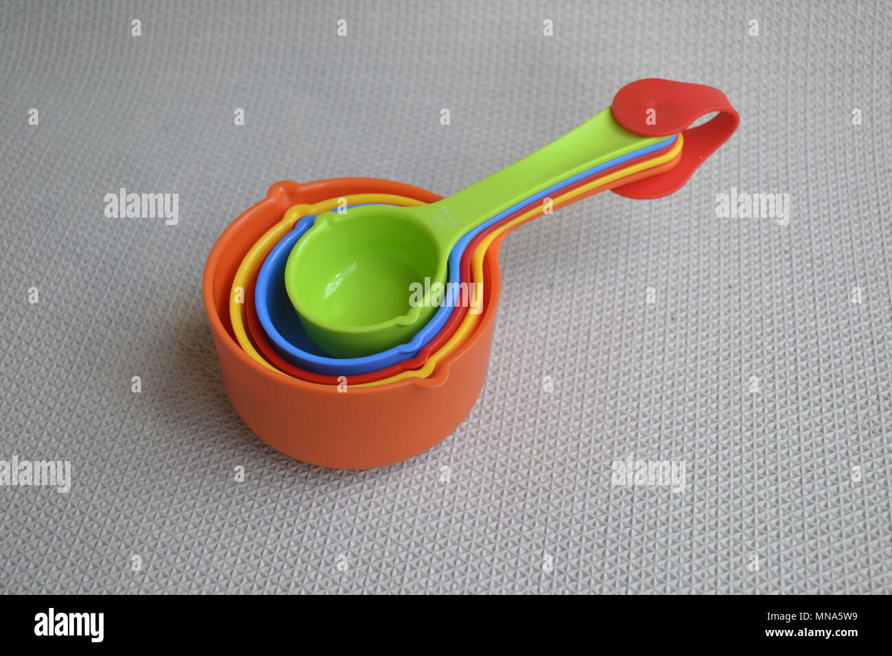 Nested Colorful rainbow kitchen measuring cups spoons colourful Stock Photo