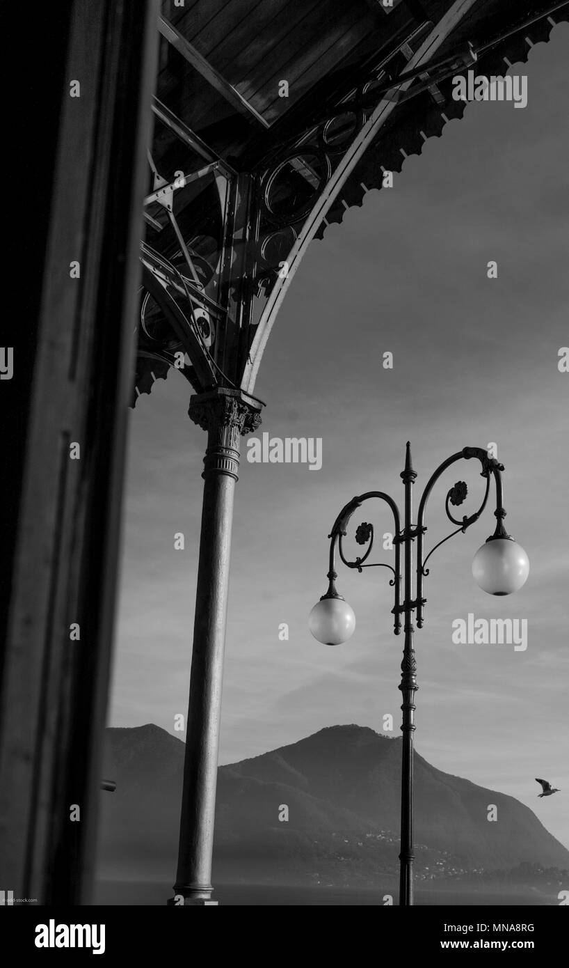 Intra, Province of Verbano-Cusio-Ossola. ITALY. Wrought Iron Roof support and Ornate Lamp post With Globe shaped Lamp shades. Monochromatic.  [© Peter Stock Photo