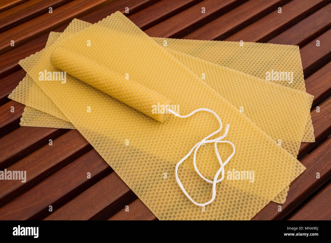 Yellow honeycomb candle on sheets on table Stock Photo