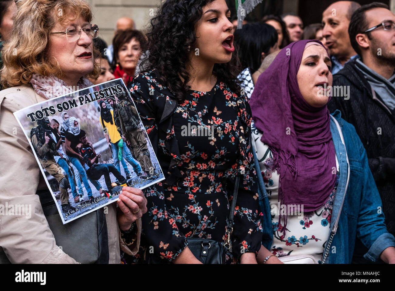 Barcelona, Catalonia, Spain. 15th May, 2018. A woman is seen with a pro-Palestinian sign next to two women shouting slogans.Hundreds of people have gathered to commemorate the day of the Nakba ''catastrophe'' or the beginning of the exodus. In the shadow of the recent genocide of the Israeli army in the Gaza Strip, the protesters have also demanded the boycott and seizure of military material to Israel. Credit: Paco Freire/SOPA Images/ZUMA Wire/Alamy Live News Stock Photo