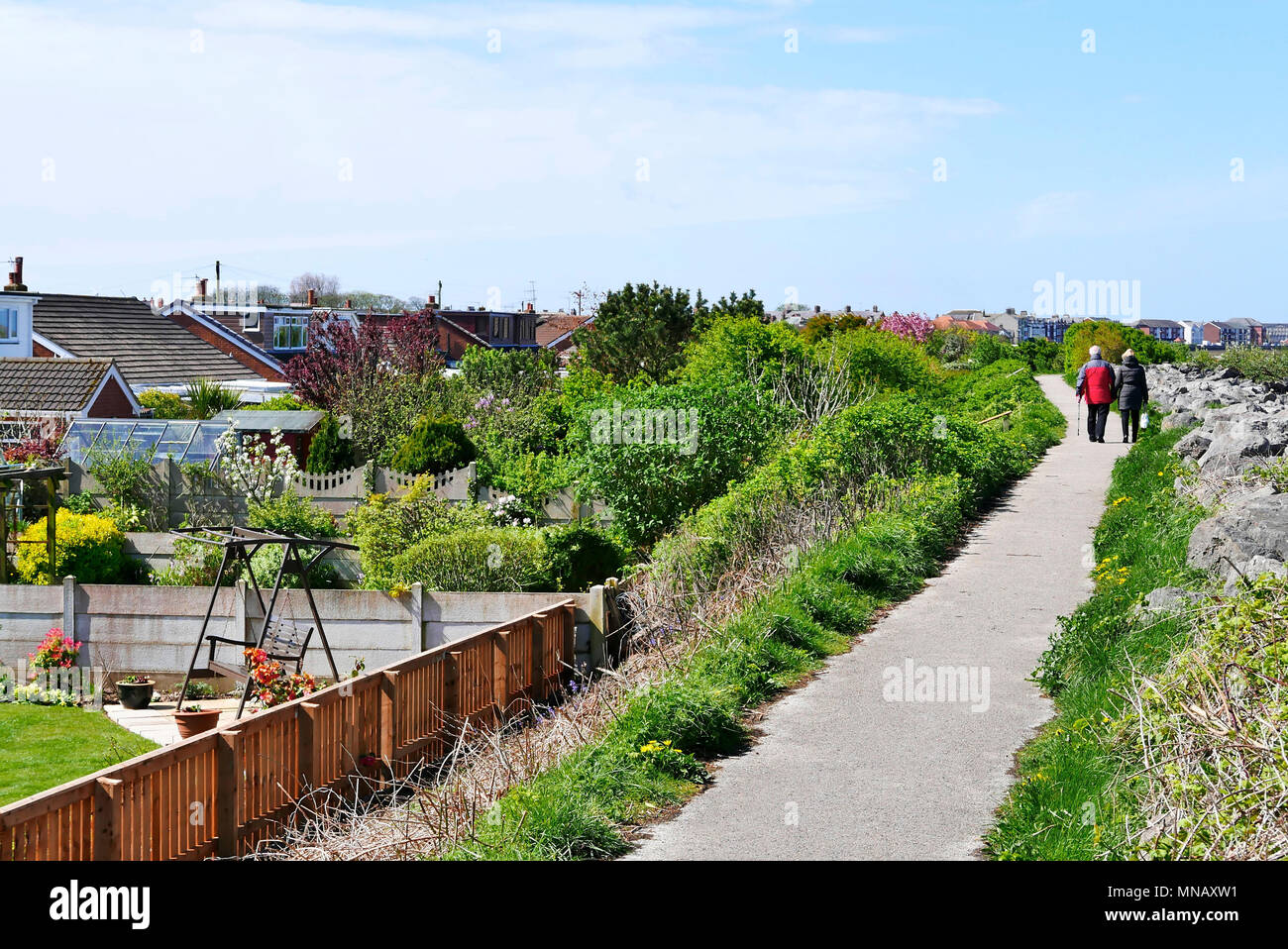 Middle aged couple walking along footpath on River Wyre estuary at Knott End,lancashire,UK Stock Photo