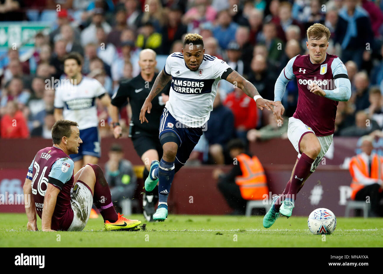 Middlesbrough's Britt Assombalonga (centre) gets away from Aston Villa's John Terry (left) and James Bree during the Sky Bet Championship Playoff match at Villa Park, Birmingham. Stock Photo