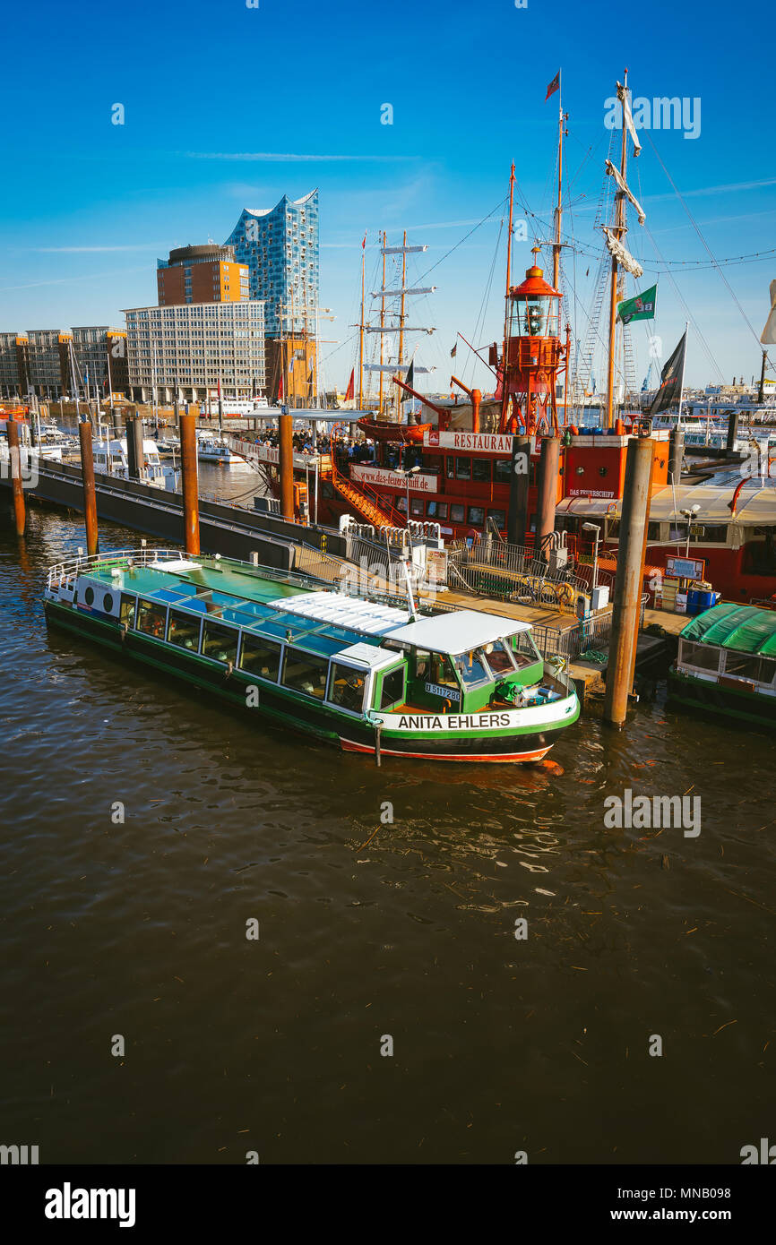 Hamburg, Germany - May 17, 2018: HafenCity, Speicherstadt: Panoramic view of Red fire patrol boat with a restaurant on the board. The modern Elbphilharmonie building in the background Stock Photo