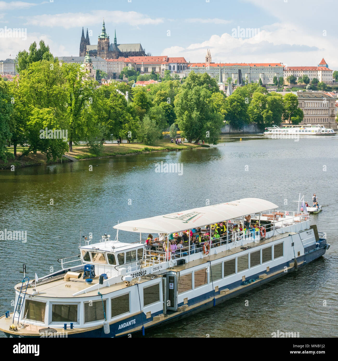 Prague Castle complex and a pleasure boat on the Vltava river, Czech Republic Stock Photo