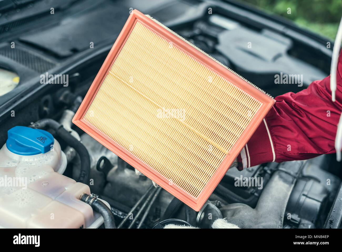 The auto mechanic replaces the car's air filter. Stock Photo