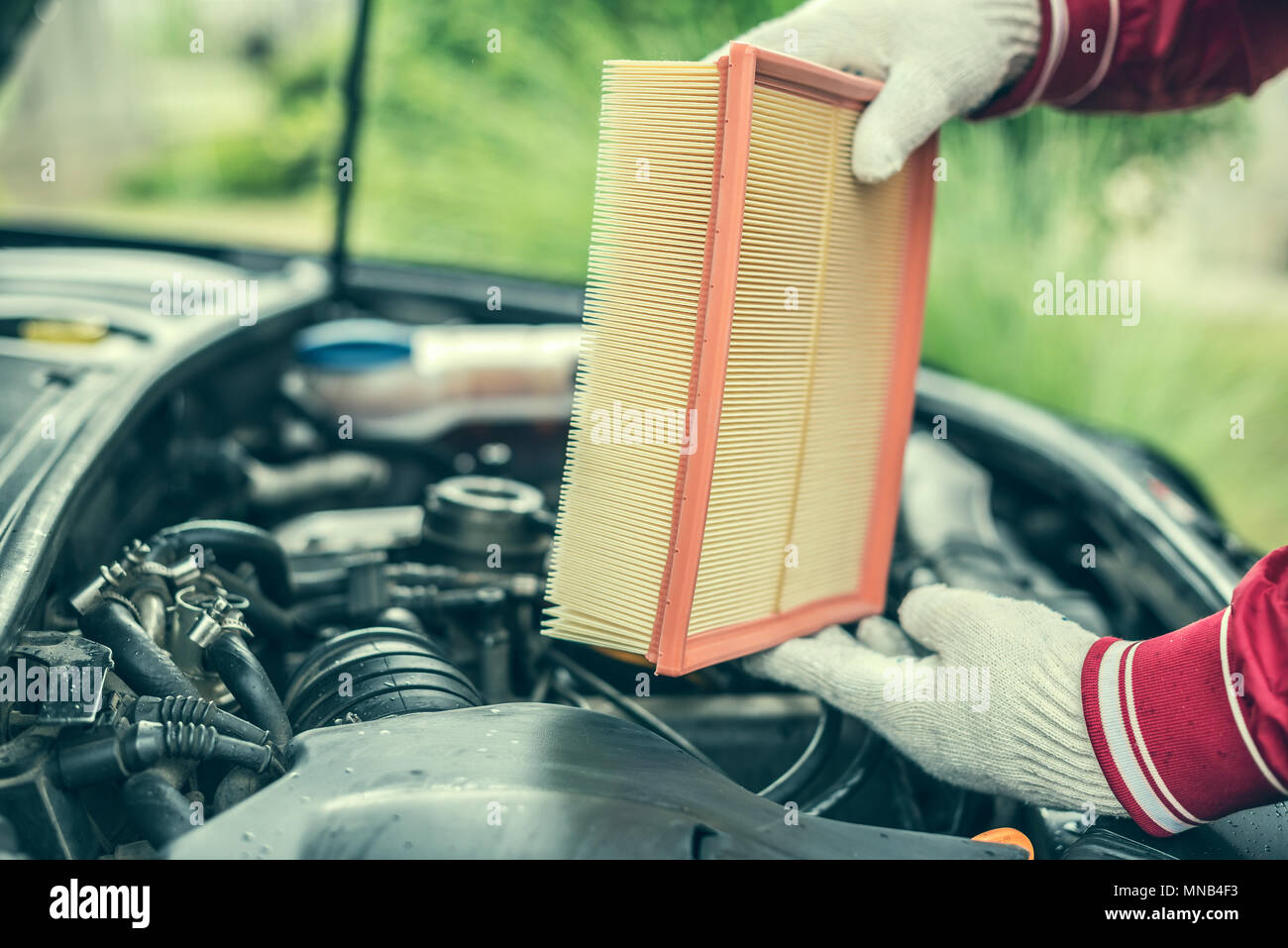 The auto mechanic replaces the car's air filter. Stock Photo