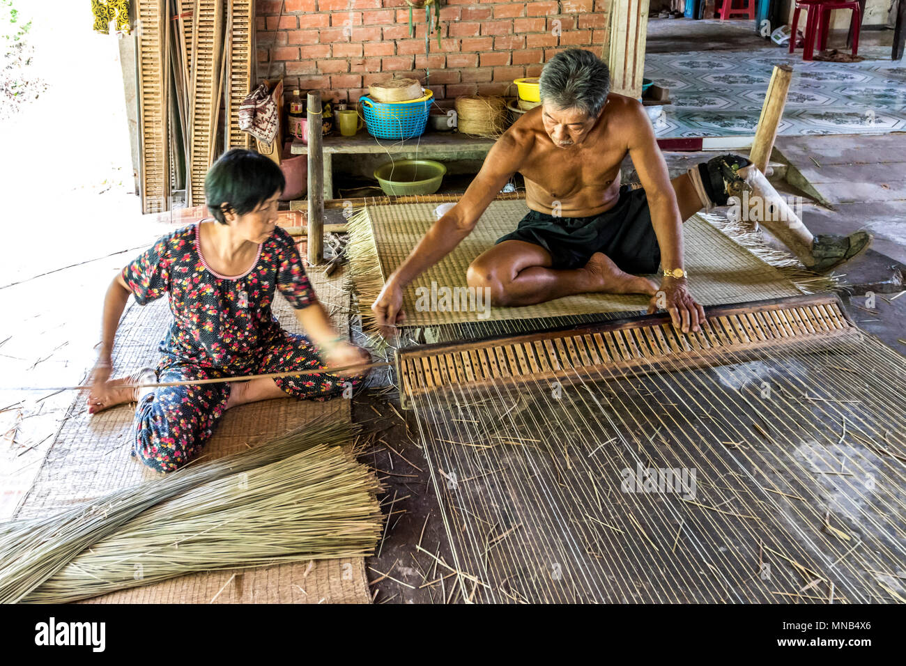 Disabled mat maker at work with assistant in Vietnam Stock Photo Alamy