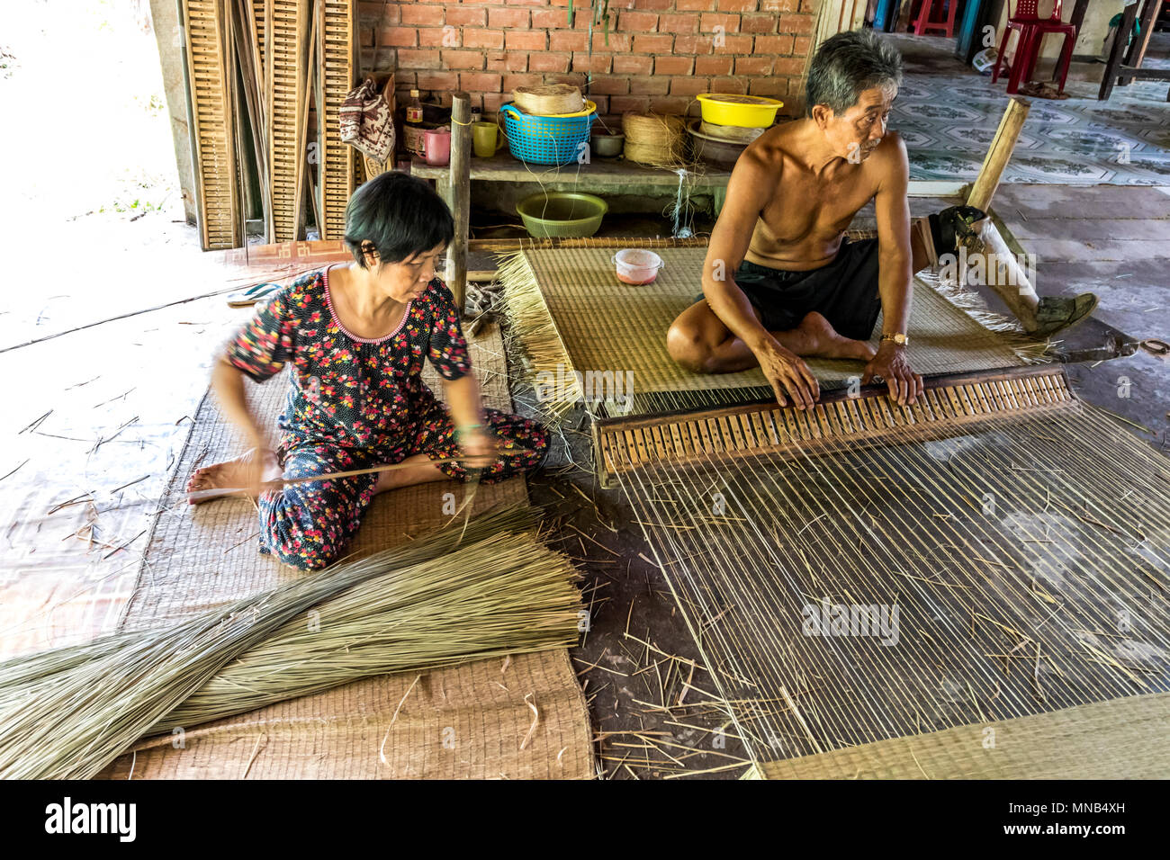 Disabled mat maker at work with assistant in Vietnam Stock Photo Alamy