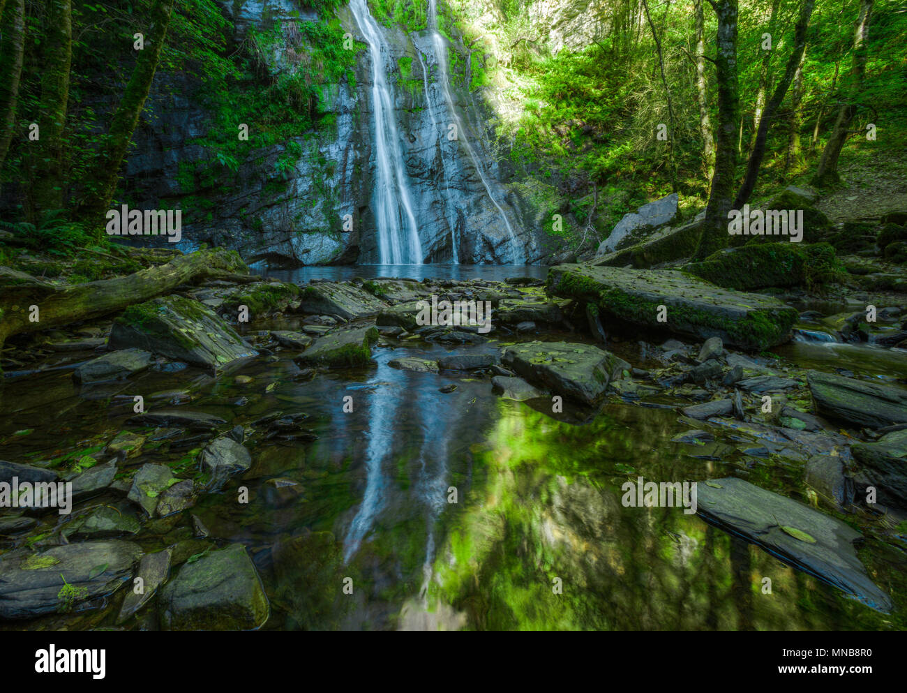 The waterfall of Vilagocende and its reflection in a pond, in Fonsagrada, Lugo, Galicia Stock Photo