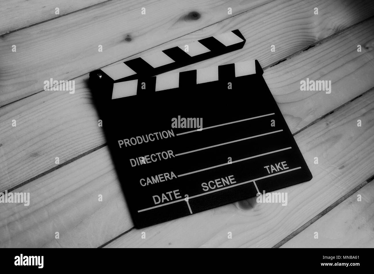 Clapper in black and white on wooden background Stock Photo