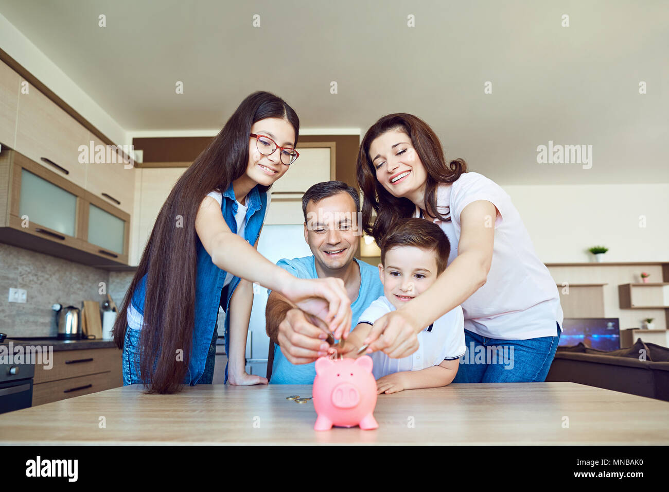 Happy family with pig piggy in the room.  Stock Photo