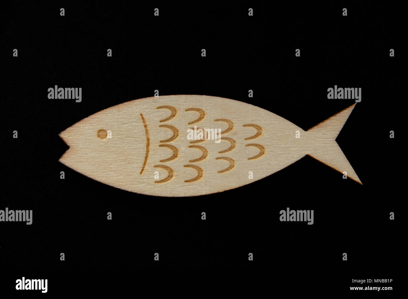 Wooden fish on black background with copy space Stock Photo