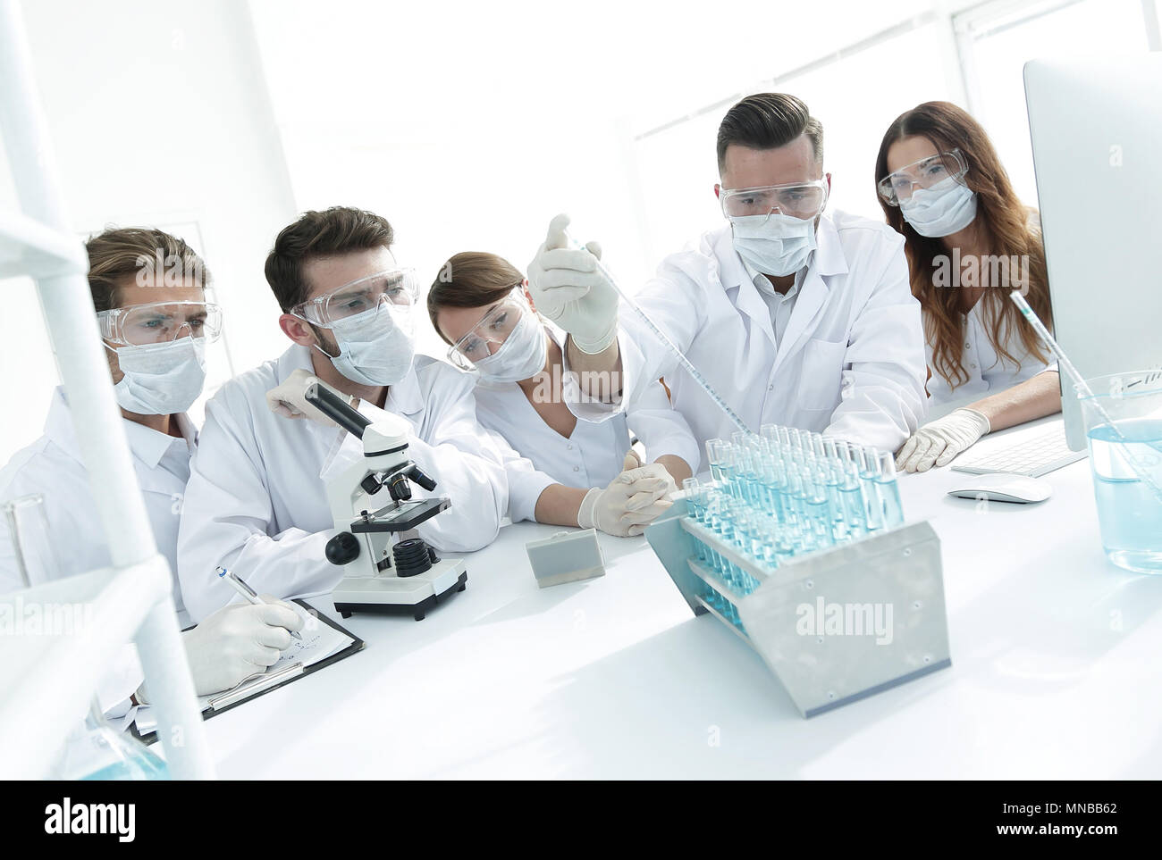 medical doctors are working with test tubes and microscope at the lab ...