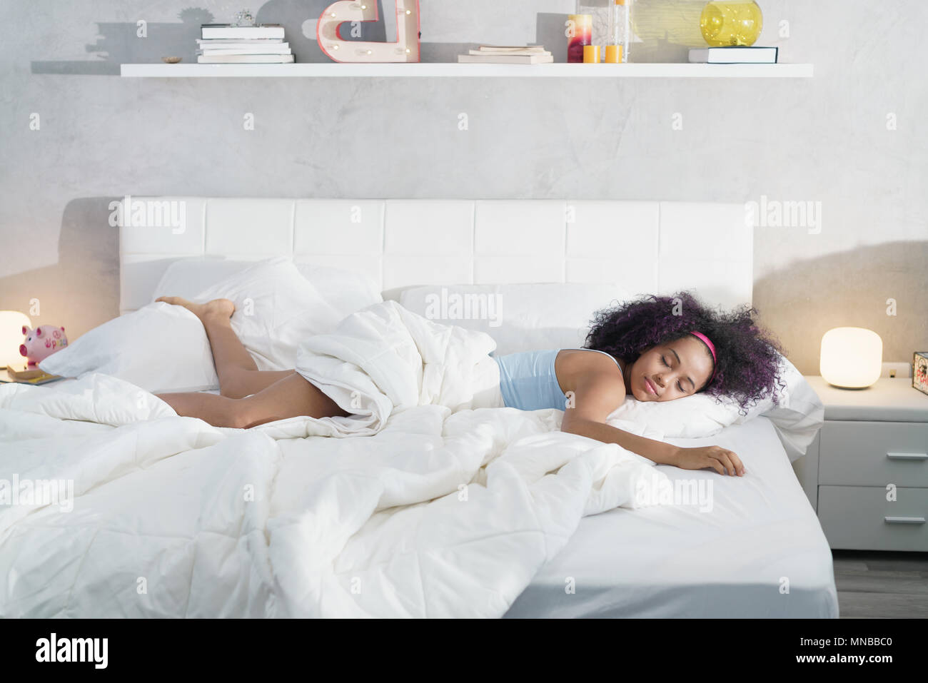 Black Woman Sleeping Alone in Large Bed Stock Photo