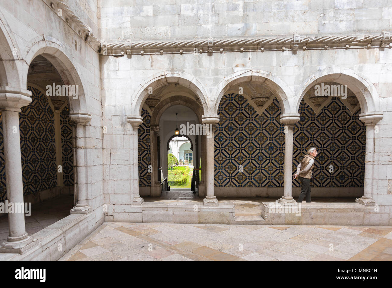 Portugal tile museum, view of a tourist walking in a cloister in the central courtyard of the Museu Nacional do Azulejo in Lisbon, Portugal. Stock Photo
