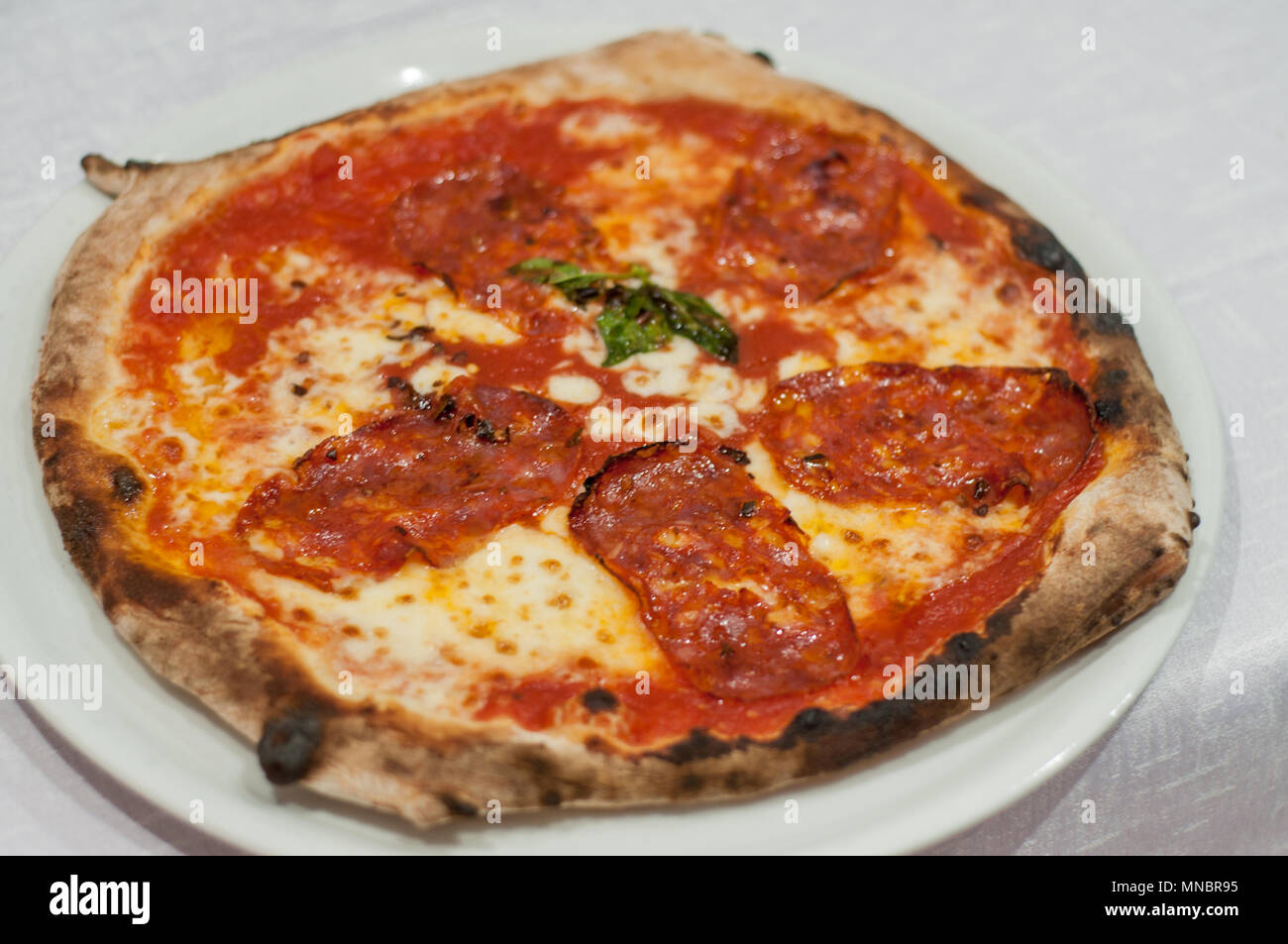 Classic, neapolitan style pizza with spicy salami Stock Photo