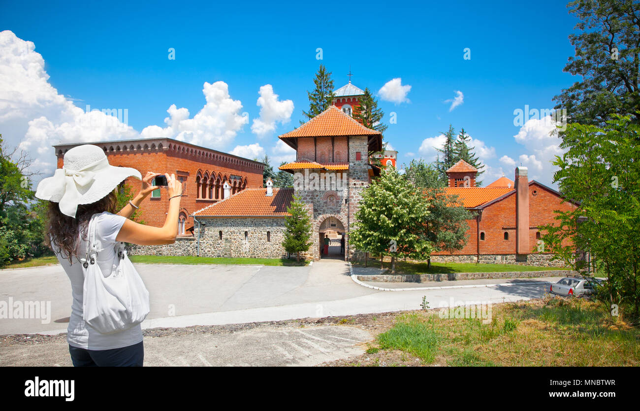 Beautiful young woman taking picture of Monastery Zica near Kraljevo, Serbia. Stock Photo