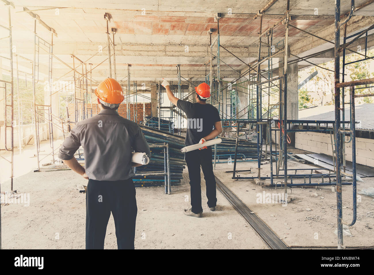 Engineer discussing with foreman about project in building construction site Stock Photo