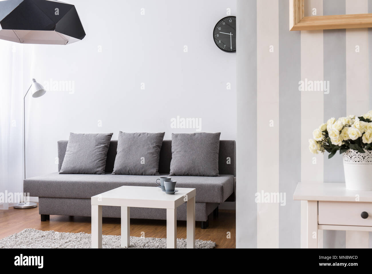 Modern living room with large, grey sofa and small coffee table. Light