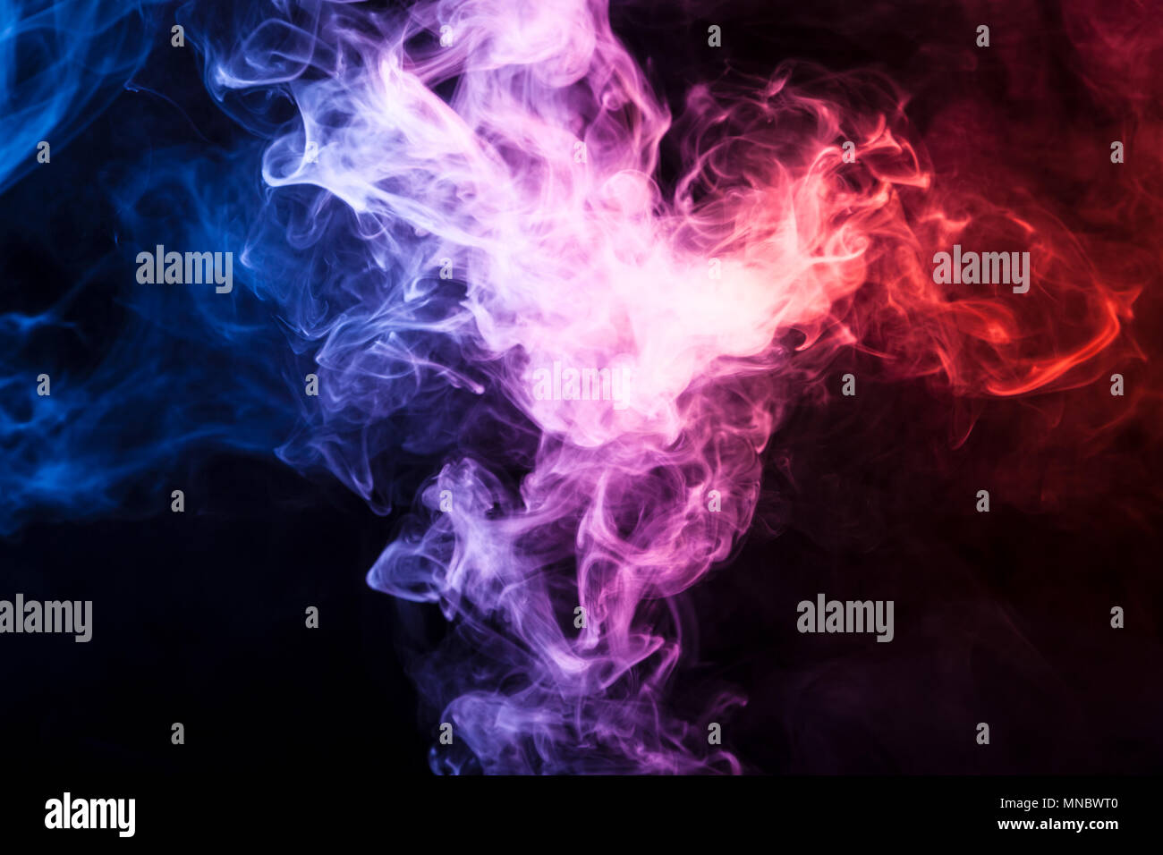 Pink and blue smoke on black background Stock Photo - Alamy