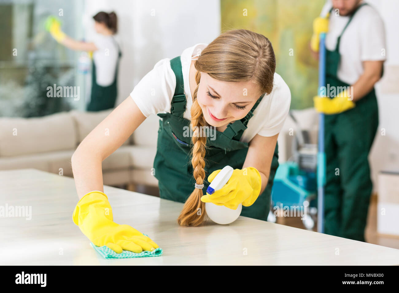 Smiling cleaning lady in yellow rubber gloves during work Stock Photo ...