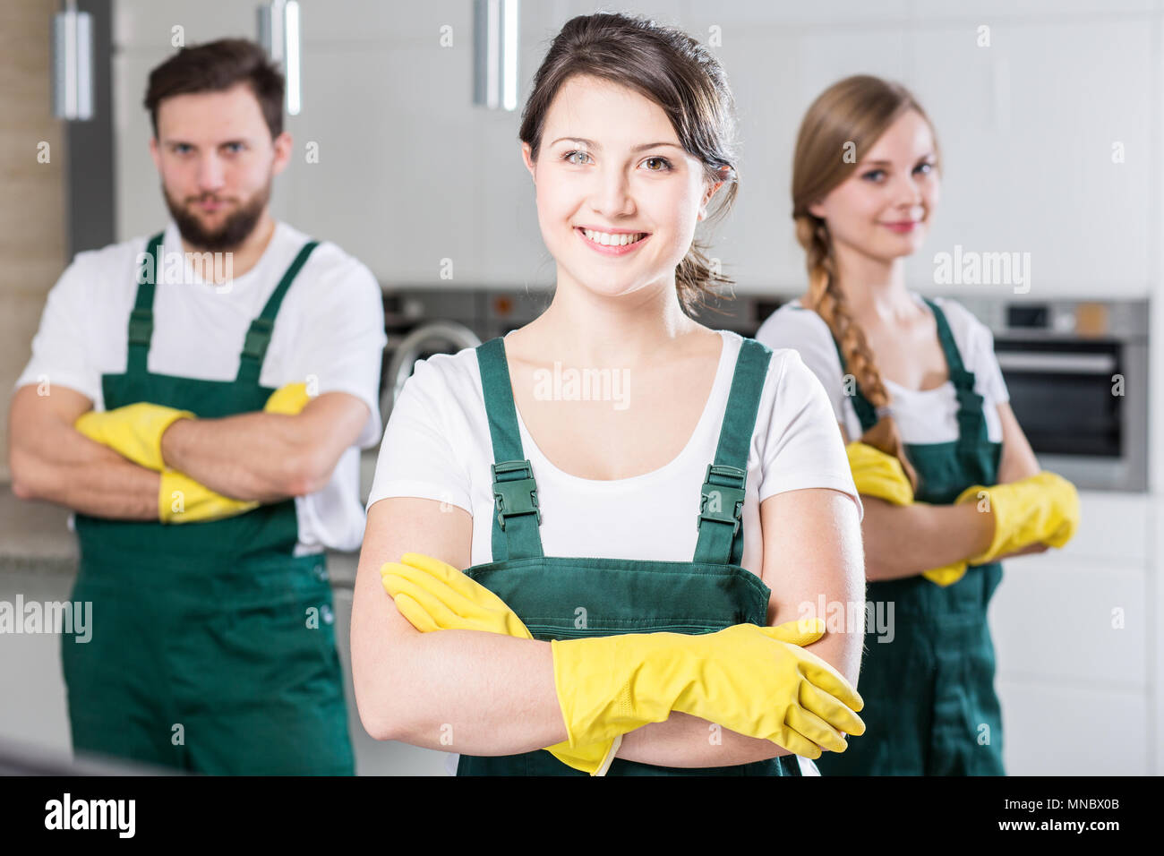 Professional cleaning team in uniforms and yellow rubber gloves Stock ...