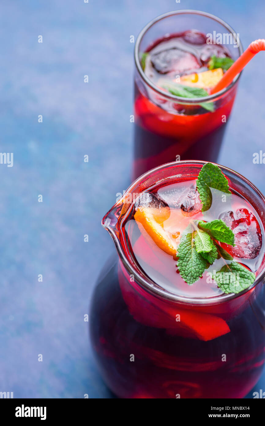 Refreshing Non-Alcoholic Spanish Sangria from Variety of Fruits Orange Citrus Pomegranate Grapes Berries and Fresh Mint in Pitcher and Tall Glass on B Stock Photo