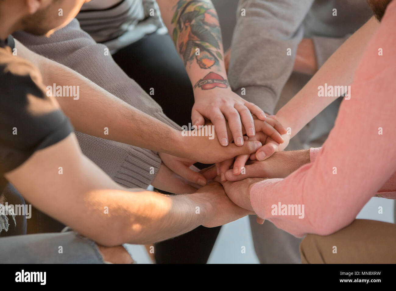 Group of people holding their hands together, close up Stock Photo