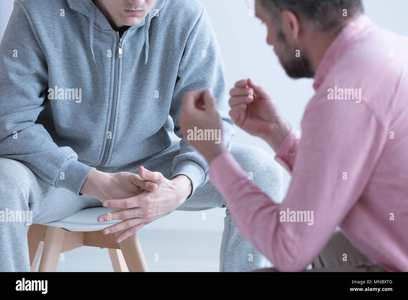 Professional man psychotherapist talking with rebellious teenager Stock Photo