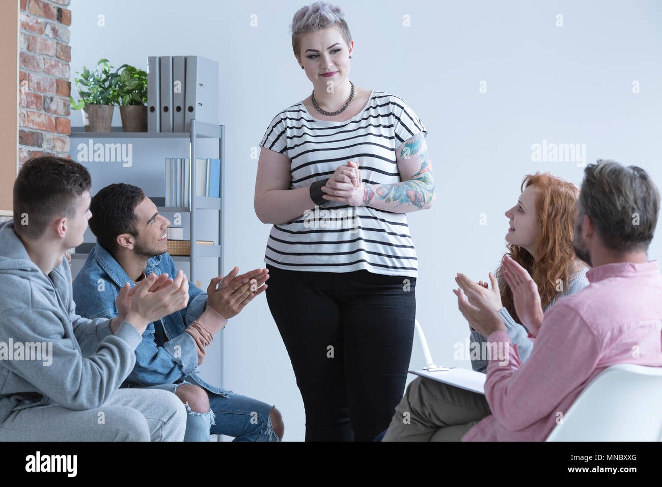 Teenage girl talking in front of support group Stock Photo