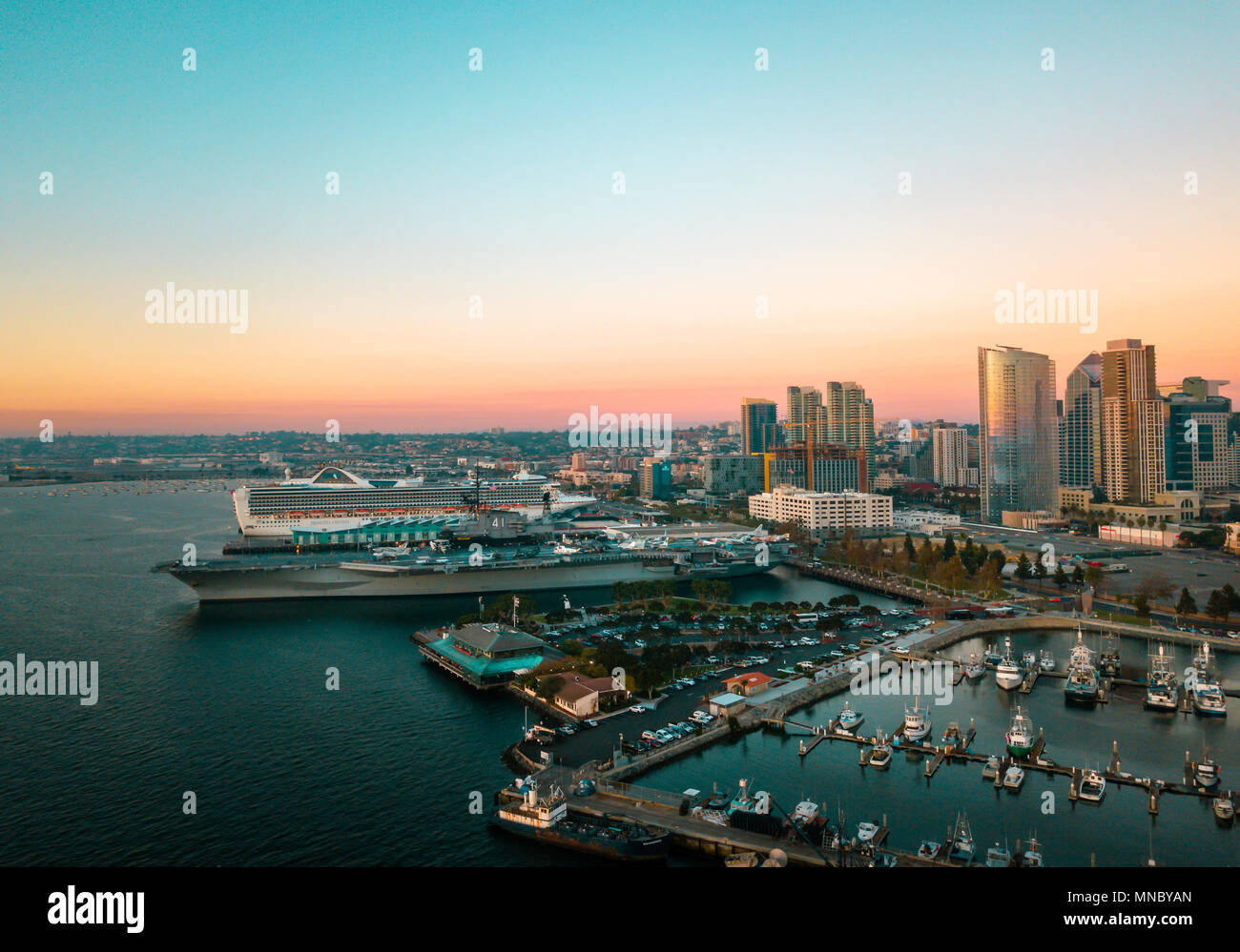 San Diego bay area with high buildings, cruisers and an aircraft carrier aerial Stock Photo