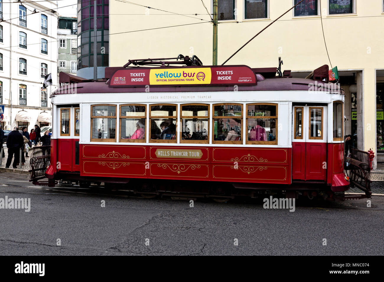 A burgundy Hills Tramcar Tour tram, run by the Yellow Bus Tours filling up with tourists in Martim Moniz Stock Photo