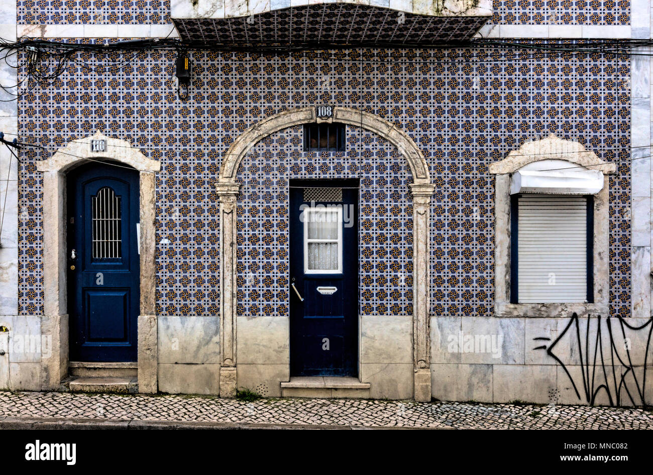 Shared tiled housefront with separate doors on the Costa do Castelo near Castelo de São Jorge Stock Photo