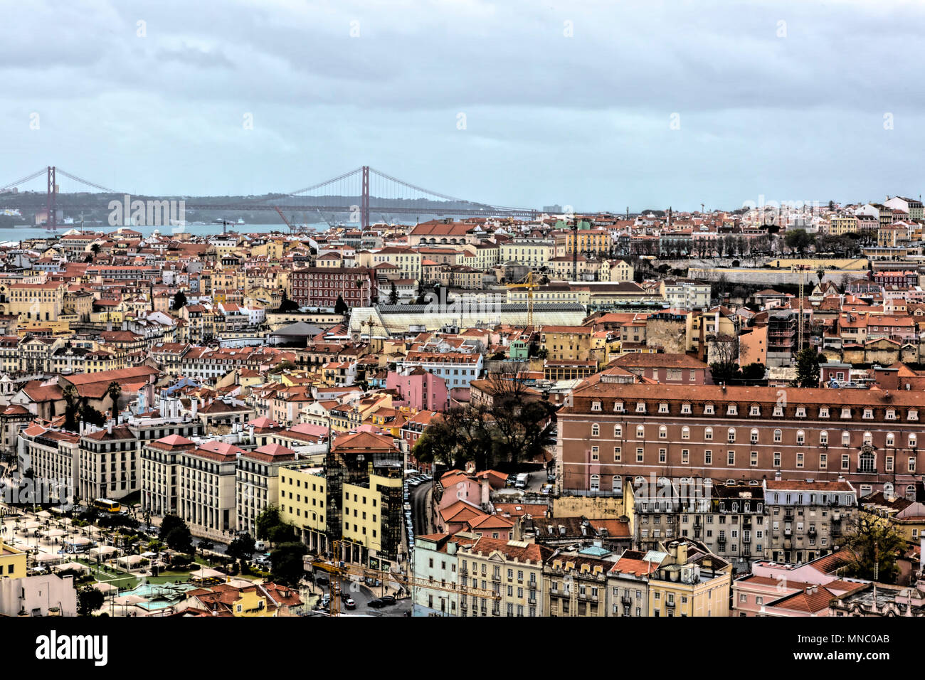 View across the roofs and buildings of Lisbon to the 25 April Bridge Stock Photo