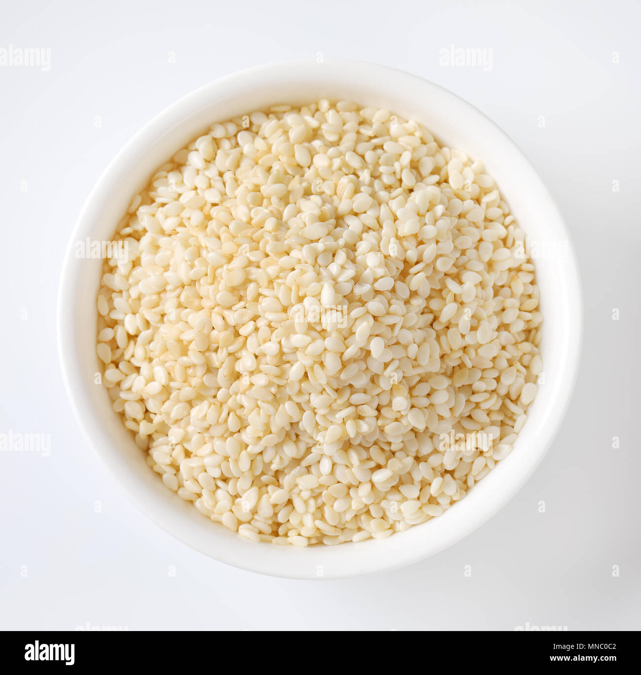 bowl of healthy sesame seeds on white background Stock Photo
