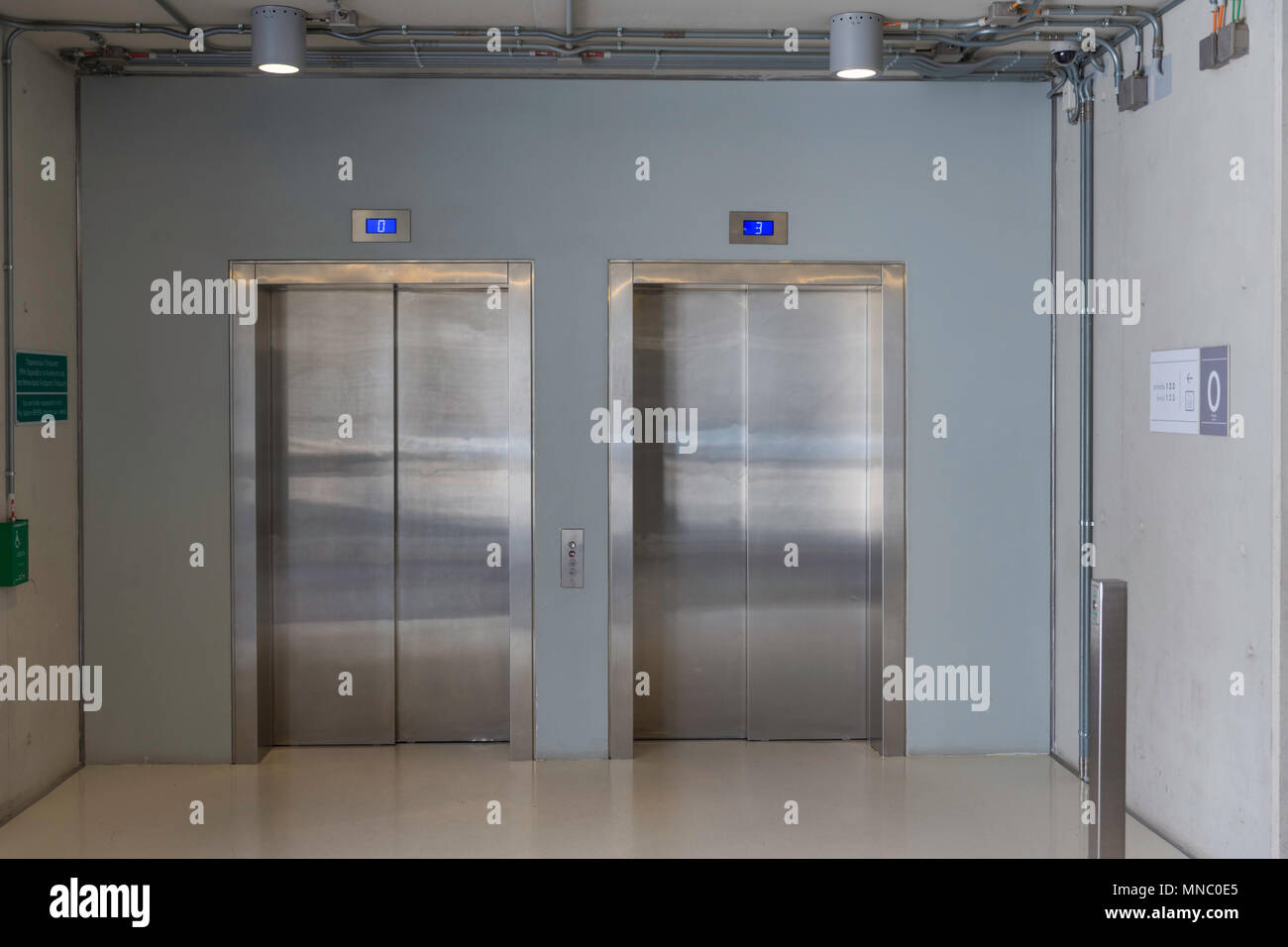 Closed elevators with buttons in corridor with concrete walls. Concept ...