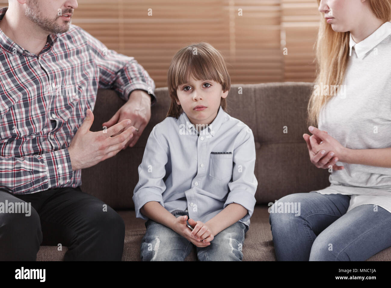Close-up of sad child and his parents arguing. Problem in the family concept Stock Photo