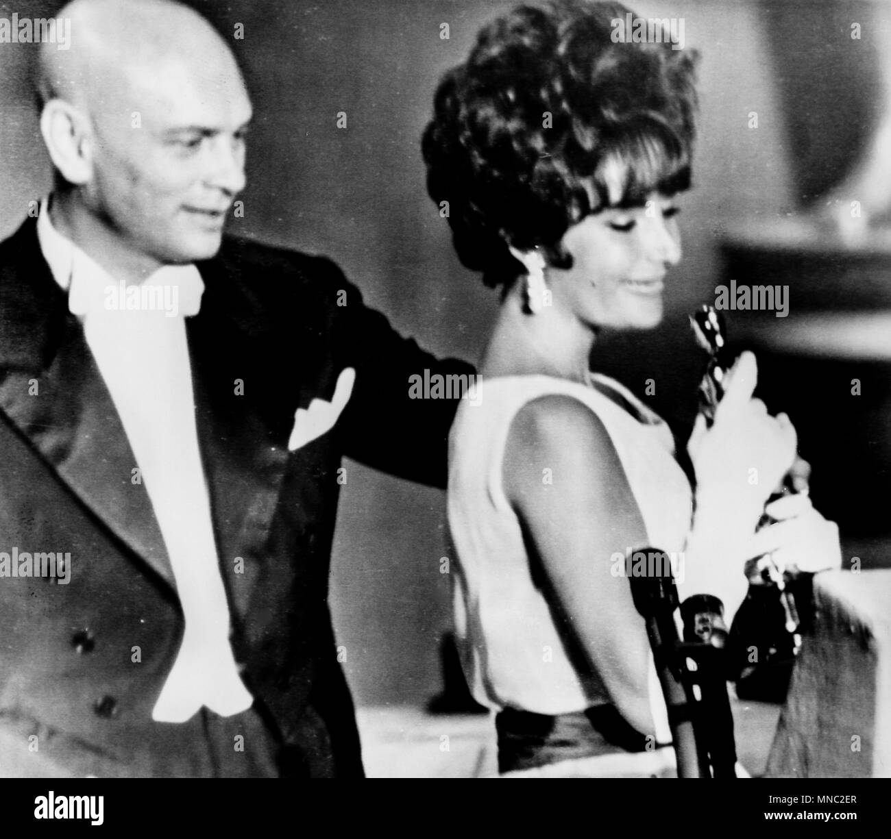 elizabeth taylor, takes the oscar as best actress in the film BUtterfield 8, yul brynner behind her, santa monica, los angeles, california, april 18, 1961 Stock Photo
