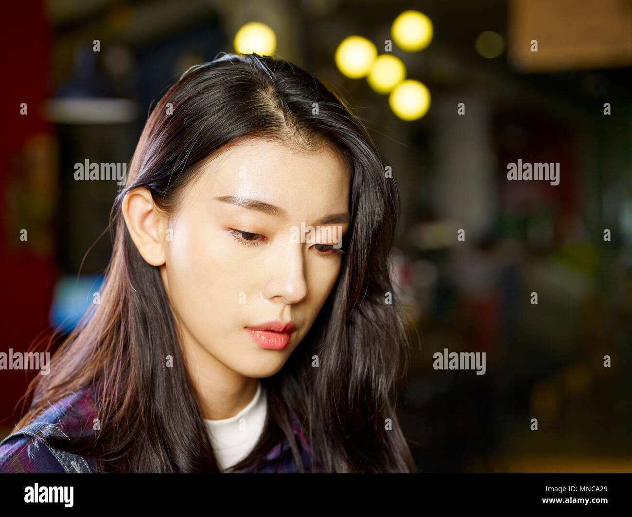 headshot of a pensive young asian woman. Stock Photo