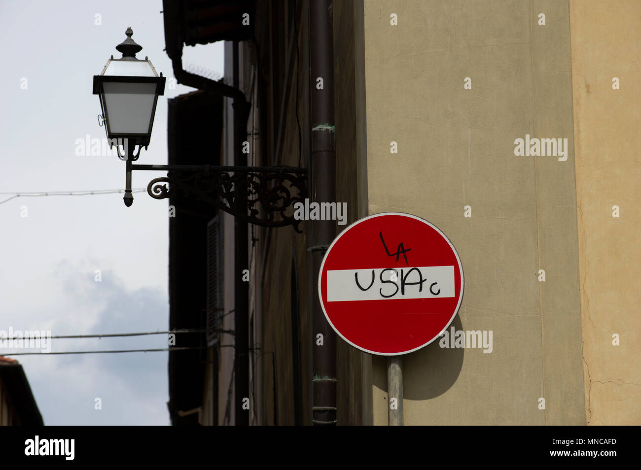 Spray painted grafitti on a street sign in spanish or italian indicating stop the USA or block the USA or dead end no entry to the USA Stock Photo