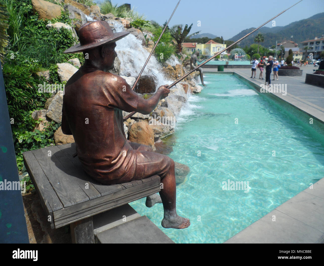 Bronze statue of a fisherman in the man made waterfall, Marmaris, Mugla  province, Turkey Stock Photo - Alamy