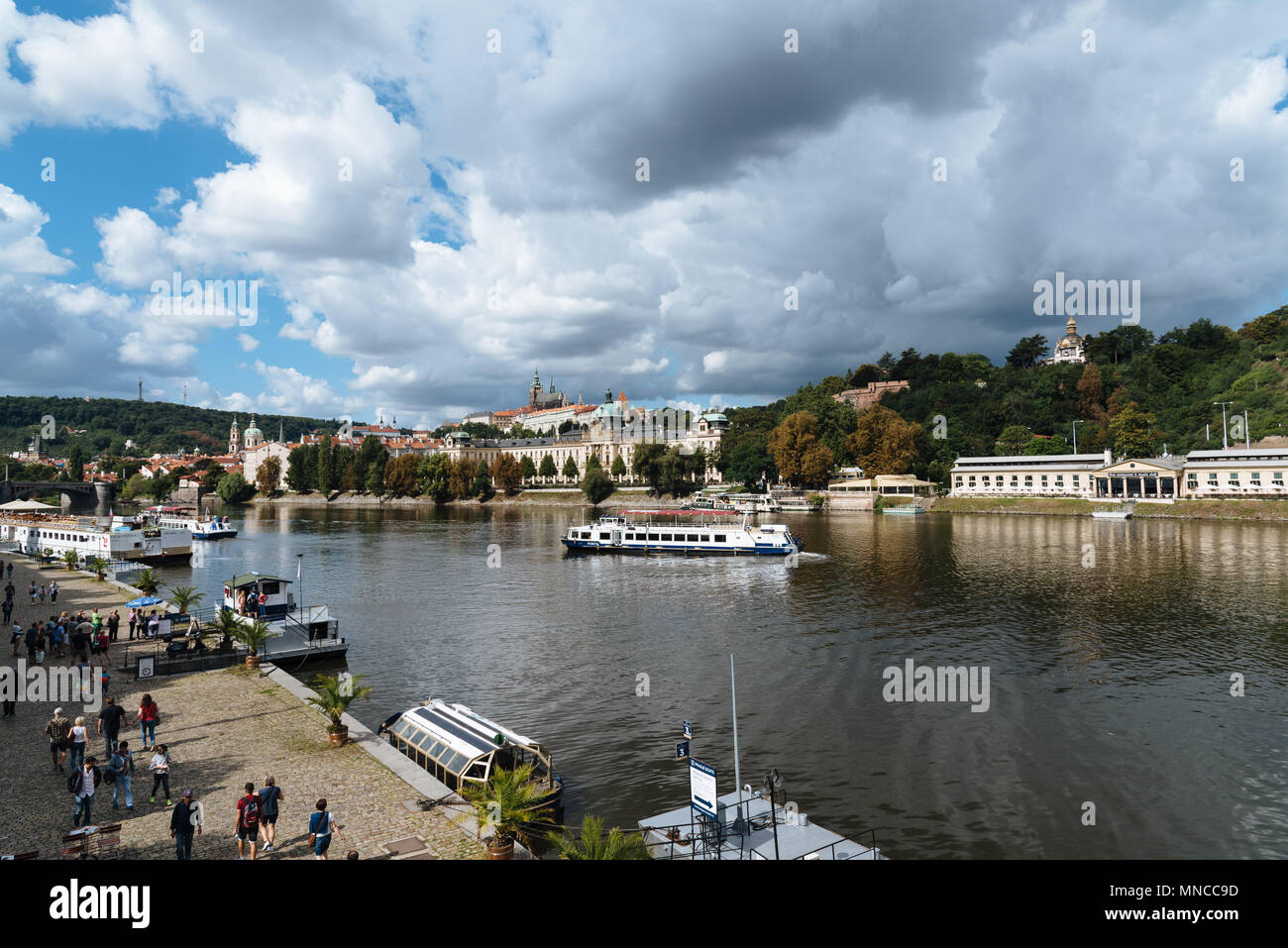 Prague,  Czech Republic - August 20, 2017: Touristic boat in Vltava River in Prague against cityscape Stock Photo