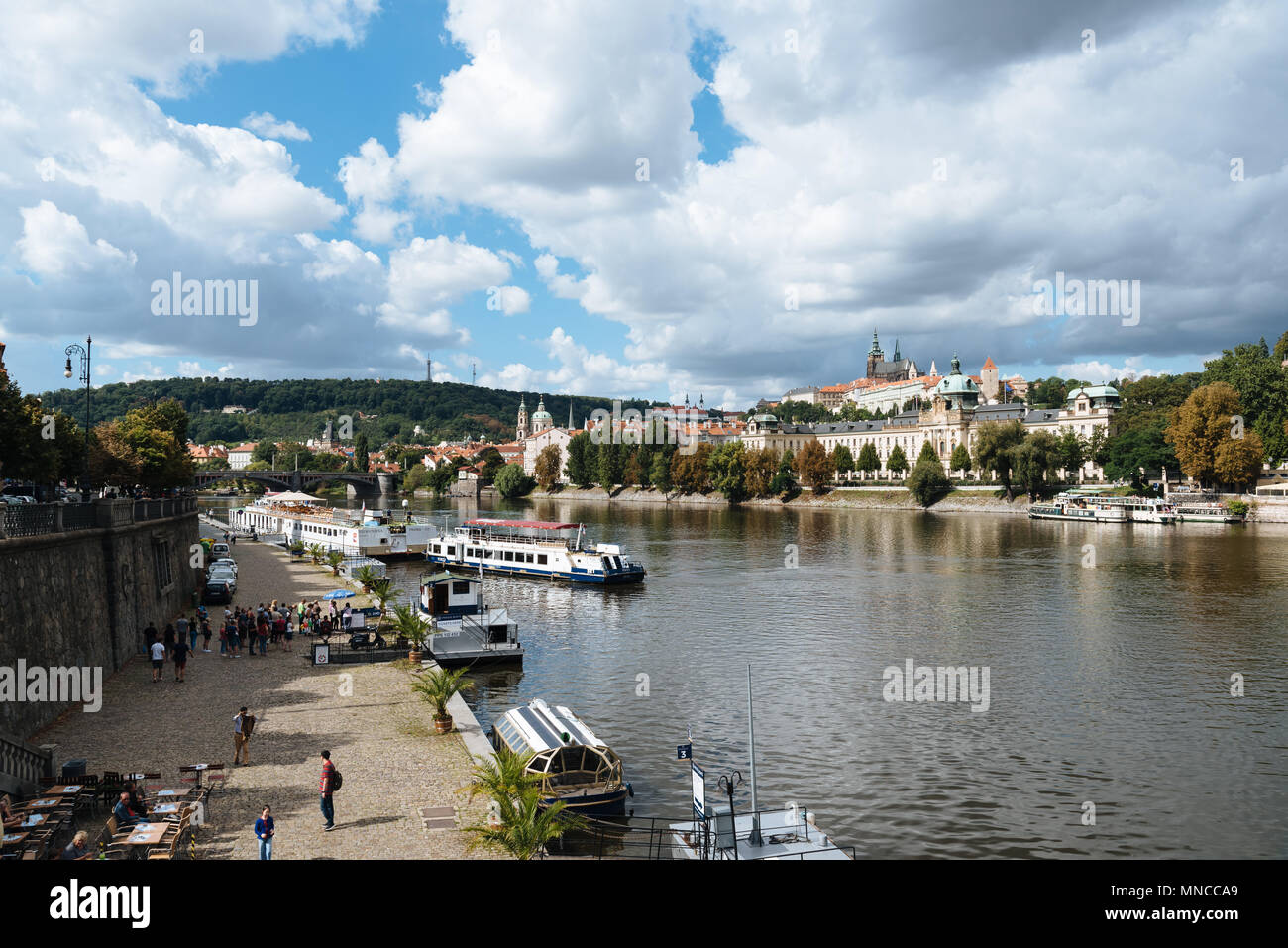 Prague,  Czech Republic - August 20, 2017: Touristic boat in Vltava River in Prague against cityscape Stock Photo