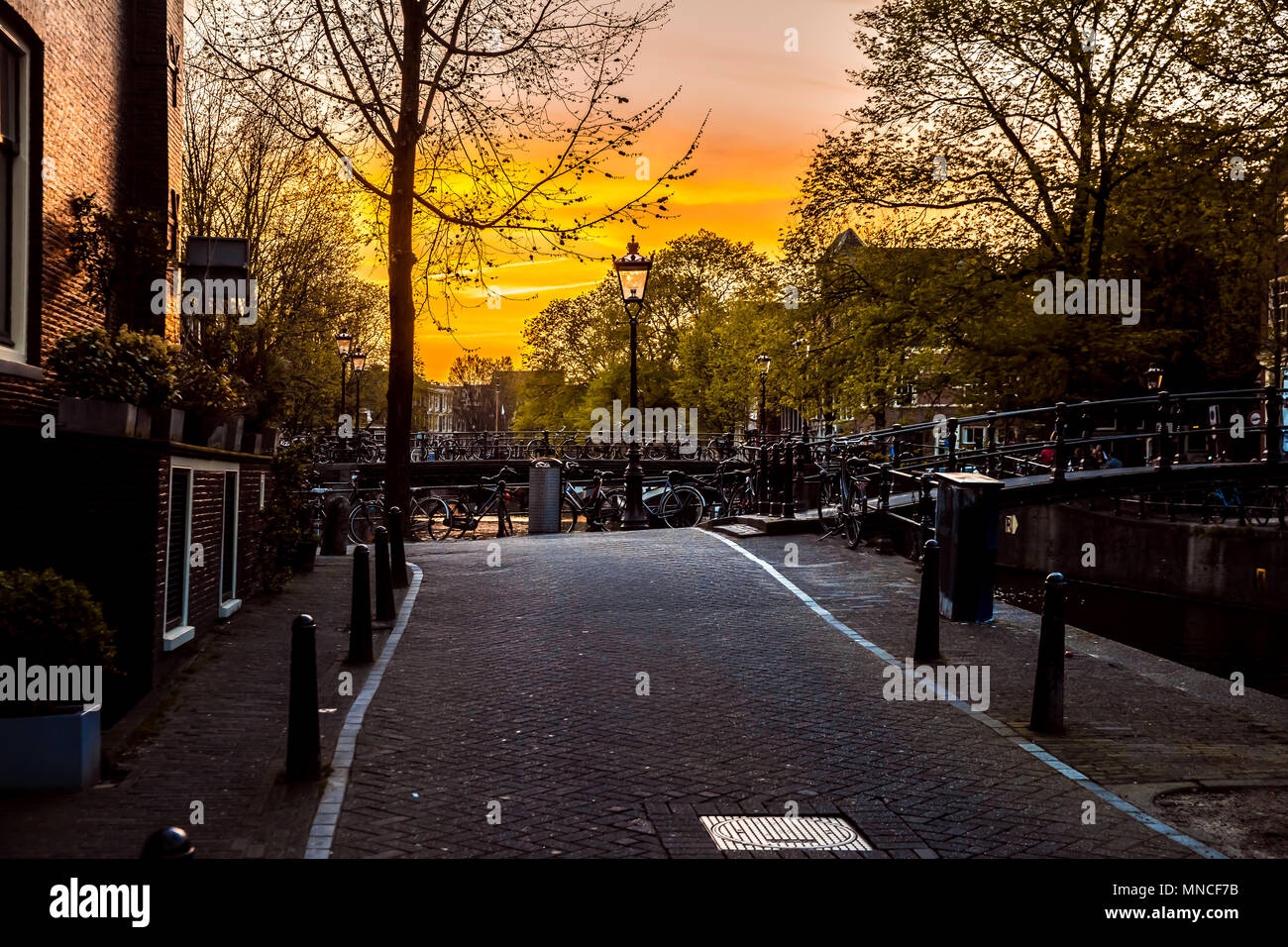 Sunset street view with bridge, bicycles in Amsterdam city, Netherlands Stock Photo